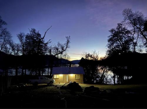 une petite maison avec un camion garé devant elle dans l'établissement Marías del Carmen, à San Martín de los Andes