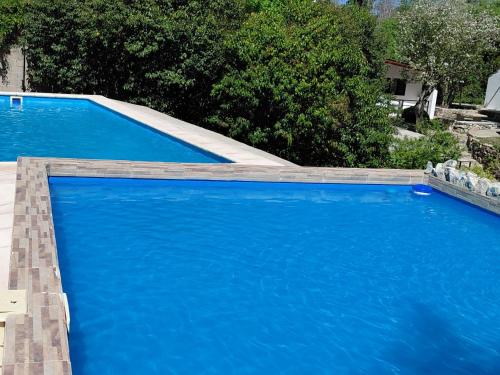 ein großer blauer Pool mit blauem Wasser in der Unterkunft Cabañas Río in Huerta Grande