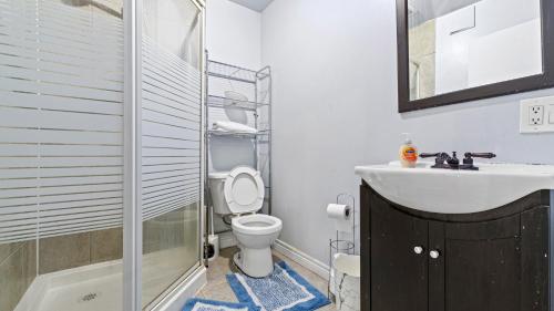 a bathroom with a toilet and a sink and a shower at Furnished Family Home near Toronto - Great Location Game Room - Backyard - Parking & Self Checkin in Pickering