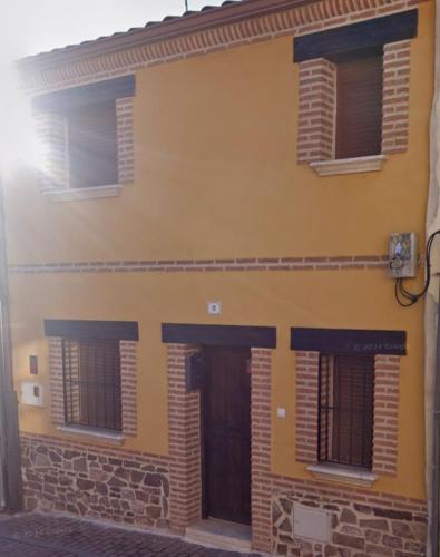 a yellow building with windows and a door at El rincón de Arévalo in Arévalo