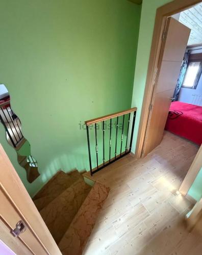 a staircase in a room with a green wall at El rincón de Arévalo in Arévalo