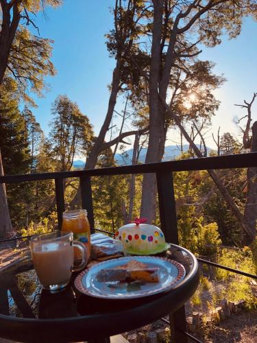 a table with a plate of food and a cup of coffee at CasaSur-37Robles-2 in Villa La Angostura