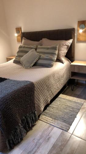 a bedroom with a bed with pillows and a rug at CasaSur-37Robles-2 in Villa La Angostura