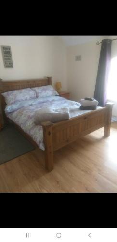 a bed with a wooden frame in a bedroom at Barrow mews views in Carlow