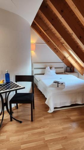 a bedroom with two beds and a table and a chair at One and Only Rooftop in Zürich