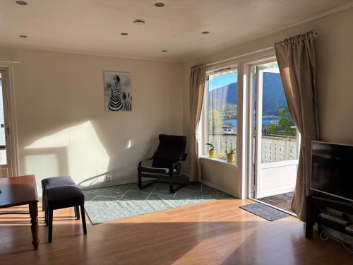 Una sala de estar con una silla y una ventana grande. en Solsiden apartment, en Sogndal