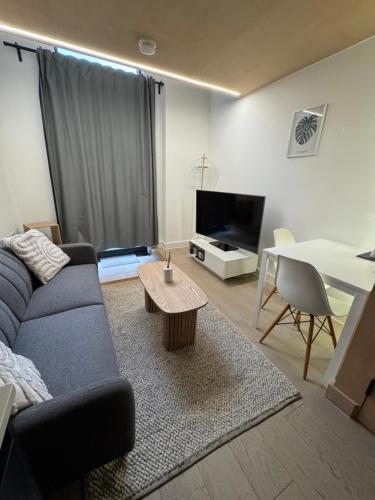 a living room with a couch and a table at Modern 1-bed Duplex+Balcony in Manchester