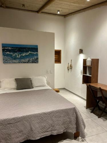 a bedroom with a large bed and a desk at Casa MCAYA in Fortim
