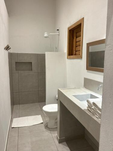 a white bathroom with a toilet and a sink at Casa MCAYA in Fortim