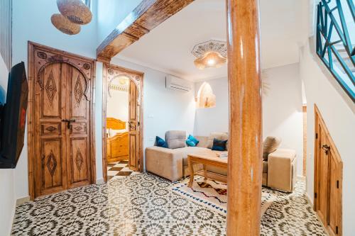 een woonkamer met een houten deur en een bank bij Appart Riad Marrakech in Marrakesh