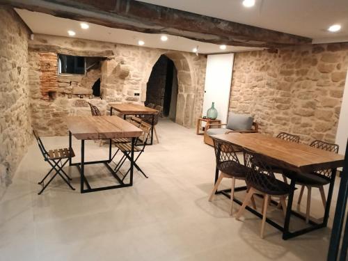 a room with wooden tables and chairs and a laptop at Patio y Calados Rioja Suites in Cenicero