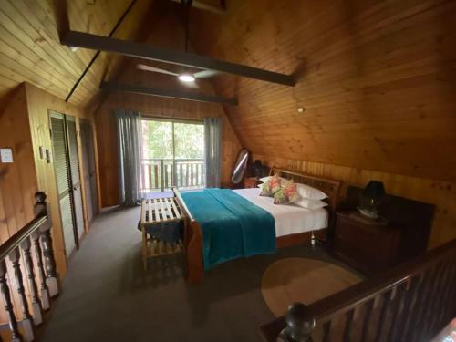 a bedroom with a bed in a wooden cabin at Springbrook Mountain Chalets in Springbrook