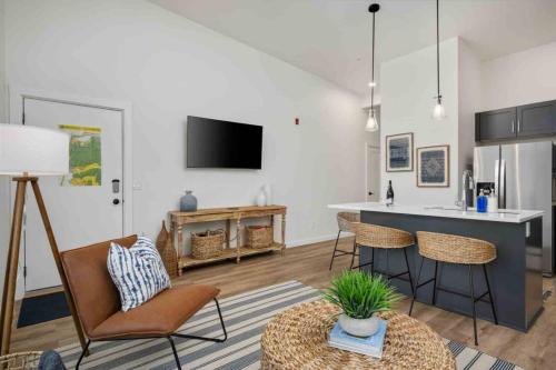 a living room with a counter and a kitchen with a table at Ebb916 Modern Loft, Heart of Taft District, Walkable to Beach in Lincoln City