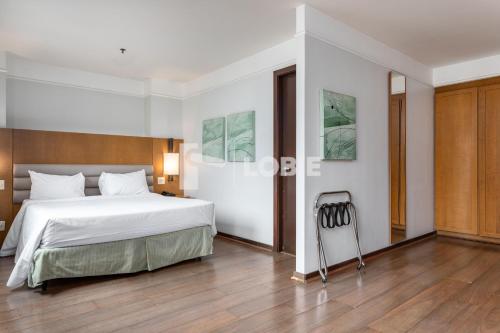 a bedroom with a large white bed and a wooden floor at Lobie Botafogo Privilege in Rio de Janeiro