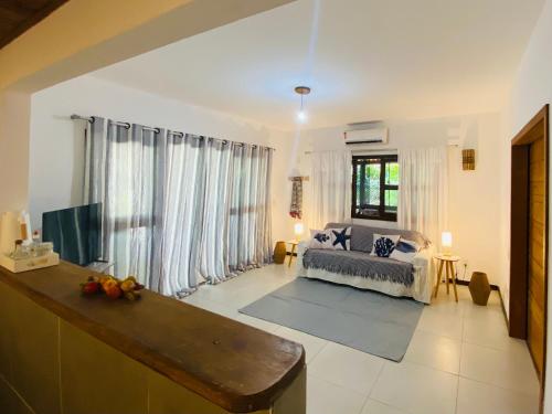 a living room with a bed and a large window at Flat Yemanjá beira-mar, 4 pessoas, quarto e sala, piscina in Marau