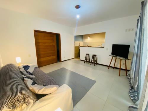 a living room with a couch and a television at Flat Yemanjá beira-mar, 4 pessoas, quarto e sala, piscina in Marau