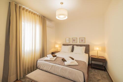 a bedroom with a bed with two towels on it at Modern 3BR Home, AC in All Rooms, Walk to 2 Beaches, Private Patio, Washer & Dryer in Ribeira Grande