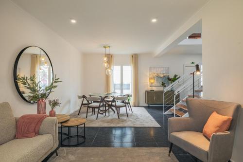 a living room with a table and a dining room at Modern 3BR Home, AC in All Rooms, Walk to 2 Beaches, Private Patio, Washer & Dryer in Ribeira Grande