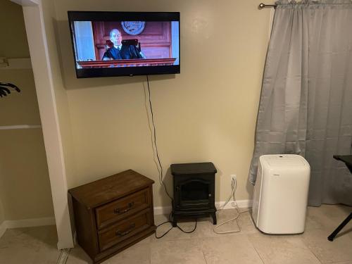 アップル・バレーにあるSky Fresh Home Stayの壁に掛けられたテレビと小さなストーブ
