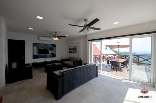 a living room with a ceiling fan and a television at ame&buho in Acapulco