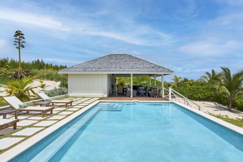 a swimming pool with two chairs and a house at Bohemia Bungalow - Two home in James Cistern