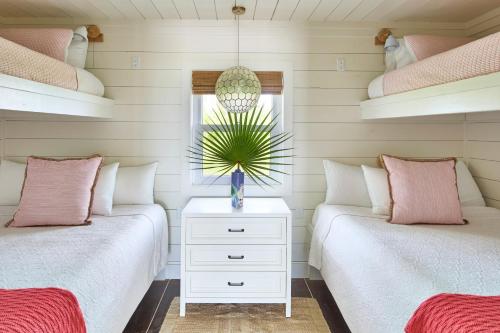 two beds in a bedroom with pink and white at Bohemia Bungalow - Two home in James Cistern