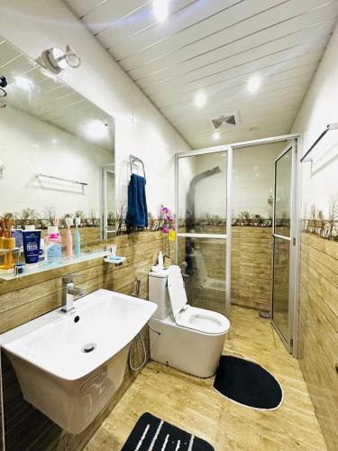 a bathroom with a toilet and a sink and a shower at A Home Away B&B in Kiribatkumbura