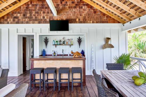 an outdoor bar with chairs and a table at Bohemia Two Bedroom home in James Cistern