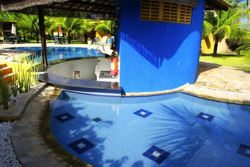 a swimming pool with blue tiles in a resort at Hotel Enseada Maracajaú in Maracajaú