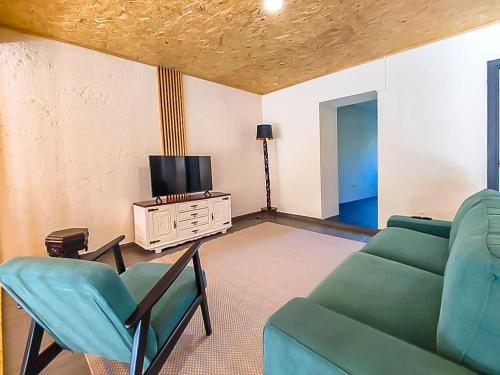 a living room with a couch and chairs and a tv at Fonte da Rosa Guest House Central Studio in Belmonte