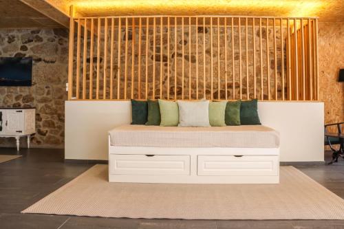 a bed in a room with a wall at Fonte da Rosa Guest House Central Studio in Belmonte