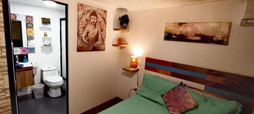 a bedroom with a bed and a bathroom with a toilet at Hostal La Casa del Puente in Santiago