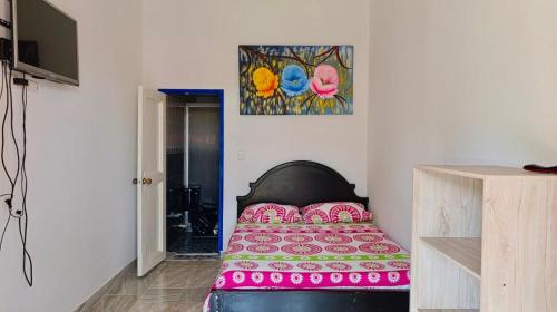 a bedroom with a bed with a pink bedspread at Chalet-Finca Hotel Loma Bonita in Alcalá
