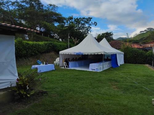 a white tent in a yard with people standing in it at Chalet-Finca Hotel Loma Bonita in Alcalá