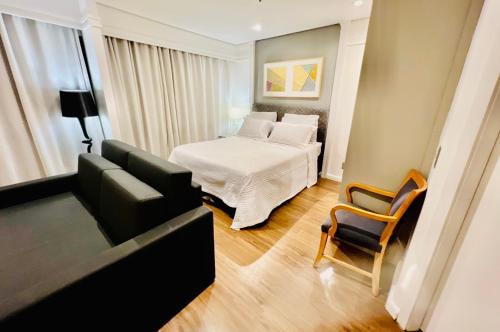 ein Wohnzimmer mit einem Bett und einer Couch in der Unterkunft Suite RDS Vila Olimpia in São Paulo