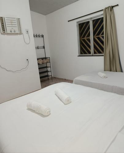 due letti in una stanza bianca con una finestra di Micro Casas, Próximas ao Terminal Rodoviário, Mercado de São Brás - 1 Unidade disponível para COP 30 a Belém