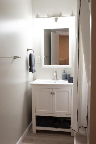 a white bathroom with a sink and a mirror at The Nautilus at JS Hubbs Guest House in Hammondsport