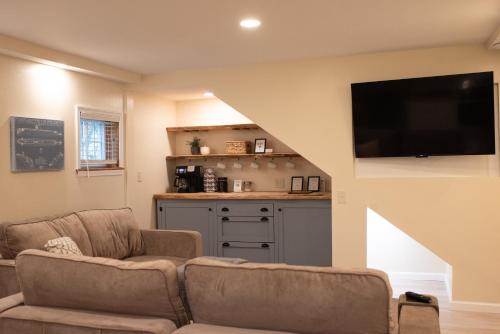 a living room with a couch and a flat screen tv at The Nautilus at JS Hubbs Guest House in Hammondsport