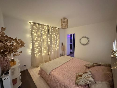 a bedroom with a bed with lights on the wall at Love Room Trappes in Trappes