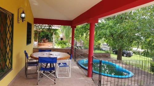 eine Terrasse mit Tisch und Stühlen und ein Swimmingpool in der Unterkunft Alojamiento Arroyo de los Patos in Arroyo de Los Patos