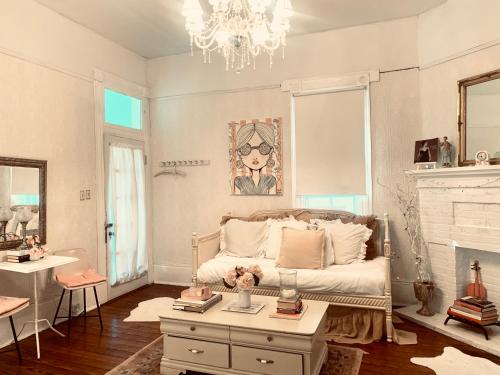 a bedroom with a bed and a table and a chandelier at 3BR Parisian Penthouse sleeps 5 w Balcony on Streetcar!! in New Orleans
