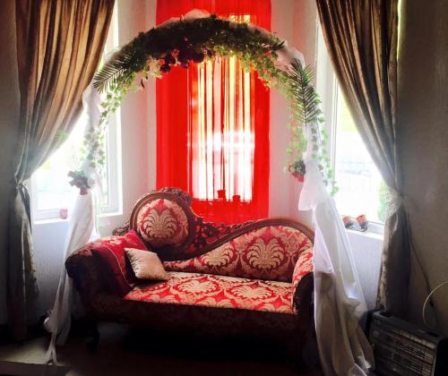 a red couch in a room with a window at Villa Bella Boutique Hotel in Kavadarci