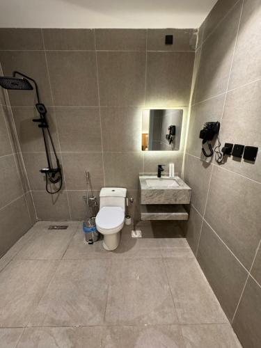 a bathroom with a toilet and a sink at luxury apartment in Al-ʿUla