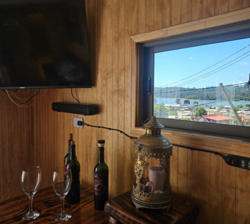 a table with two wine glasses and a window at Cabaña Constitución in Constitución