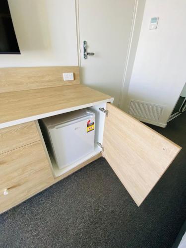 a desk with a door open and a dishwasher underneath it at Sea View Hotel Room Heart of Surfers Paradise in Gold Coast