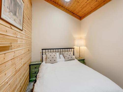a bedroom with a bed and a wooden wall at Mayfield Lodge - Uk39917 in Heckington