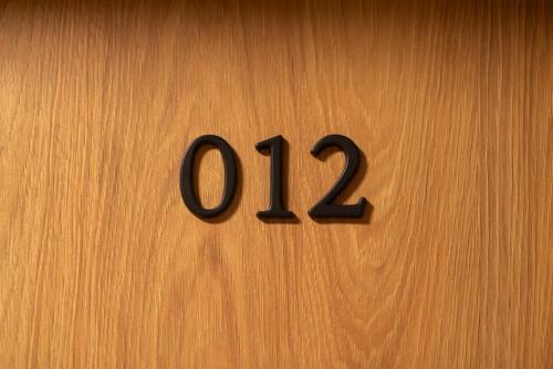 a wooden door with the number on it at Rajska7712 in Wrocław