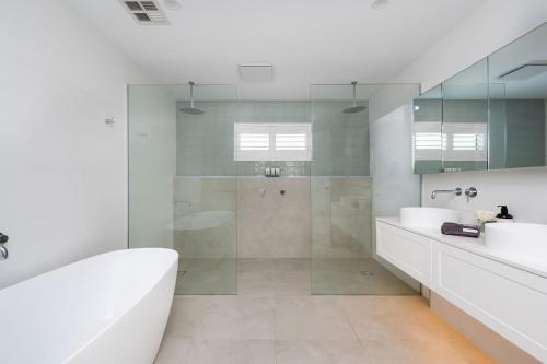 Un baño con bañera, lavabo y ducha. en Ocean Pearl - Oceanview Luxe Escape with Pool, en Tootgarook