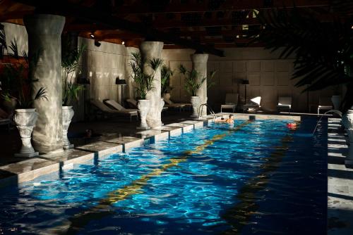 a swimming pool in a building with blue water at Lopota Lake Resort & Spa in Napareuli