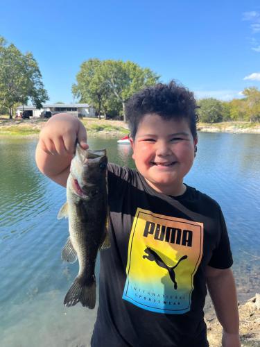 a young boy holding a fish in his hand at Gone Fishin' Suite 4 by The Lodges at Fossil Creek in Shay